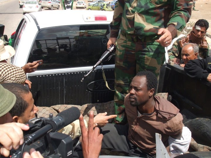 News crew filming alongside a technical vehicle during the Libyan revolution