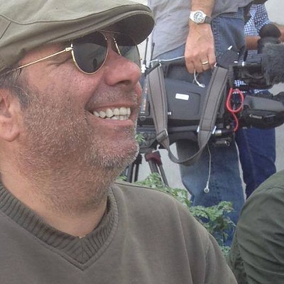 Ramy Francis on set, a camera crew working behind him